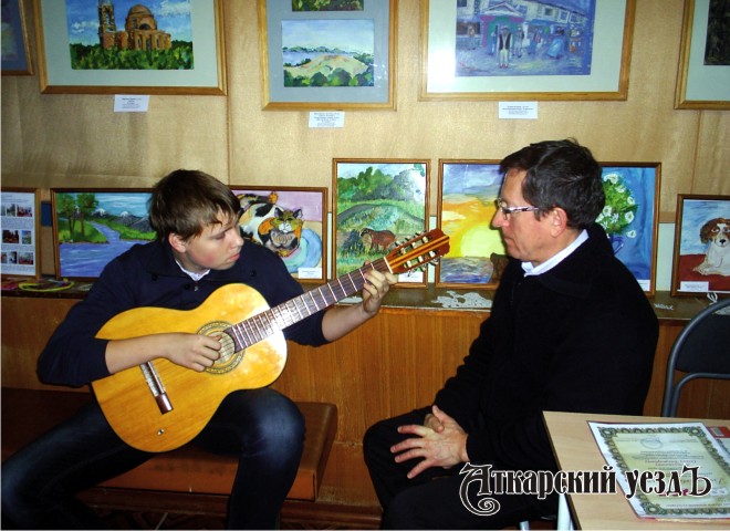 Ученик преподавателя музыки Михаила Словеснова играет вальс на гитаре на 34-м дне рождения музея