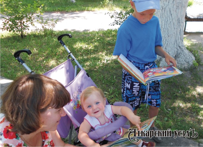 Ребенок в коляске читает книгу