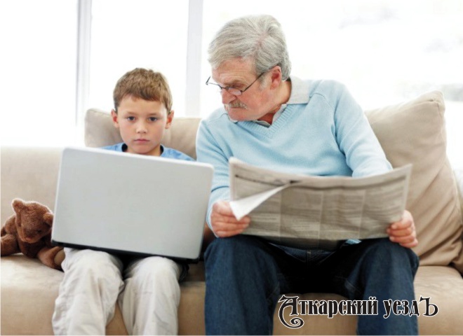 Внук с планшетом и дедушка с газетой