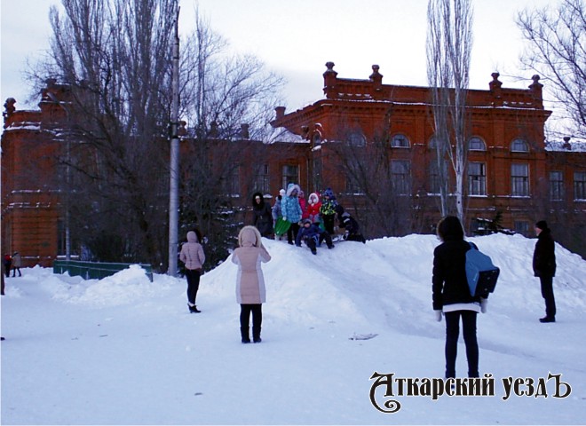 Дети ктаются на снежной горке на Площади звезд в Аткарске на новогодние праздники