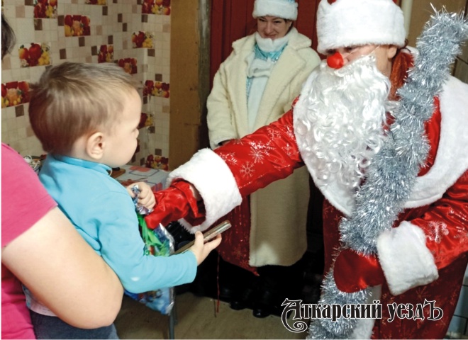 Дед Мороз вручает подарок ребёнку