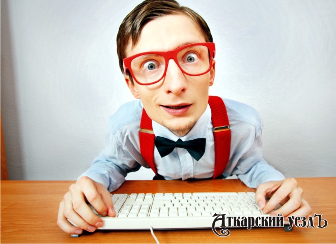 Смешной человек в очках за компьютером