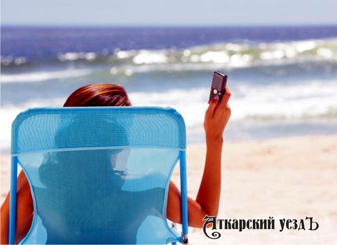 Девушка с телефоном на берегу океана
