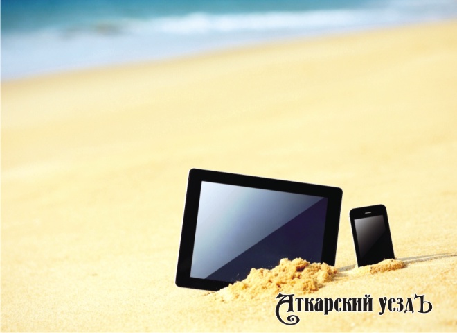 Смартфон и планшет на пляже в песке