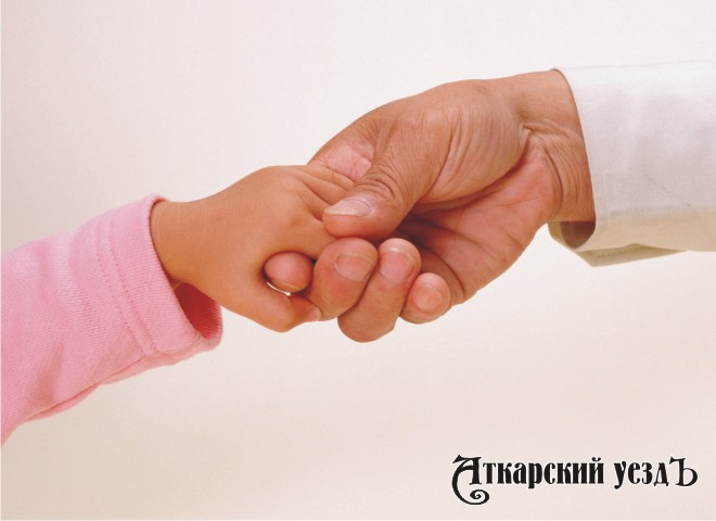 Маленький ребенок держит за руку взрослого человека