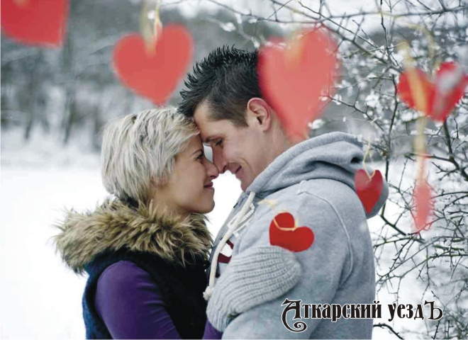 Женщина и мужчина целуются в зимнем лесу