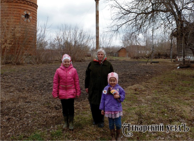 Лариса Семеновна Кузьмичева с внучками у своего дома в Озерном
