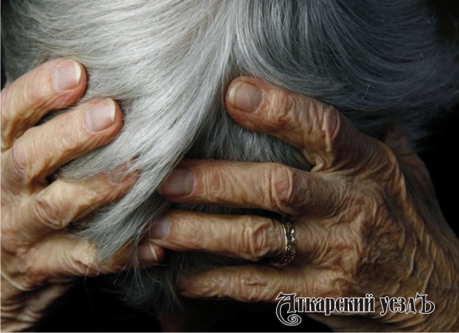 Пожилая женщина держится за голову