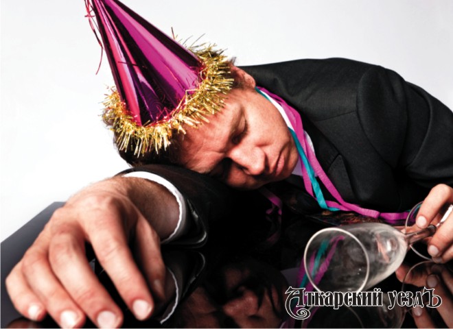 Мужчина в праздничном колпаке лежит пьяный