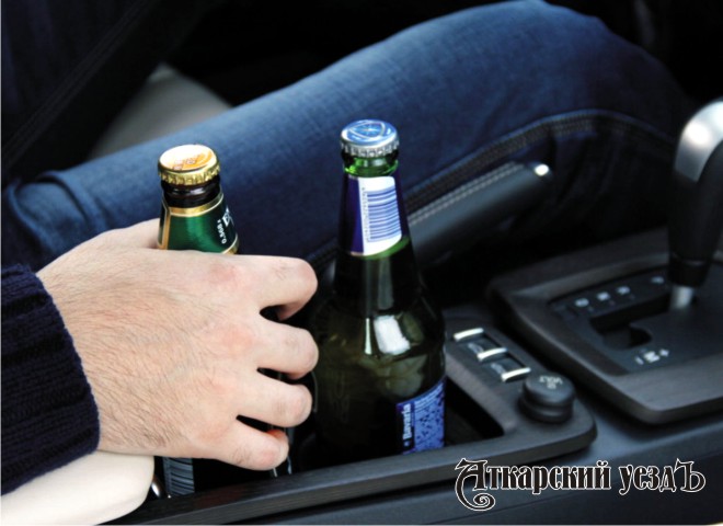 Мужчина с двумя бутылками пива в машине