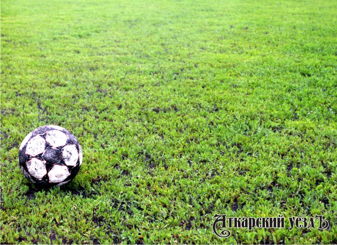 Мяч на футбольном зеленом поле