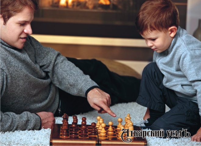 Папа с сыном играют в шахматы