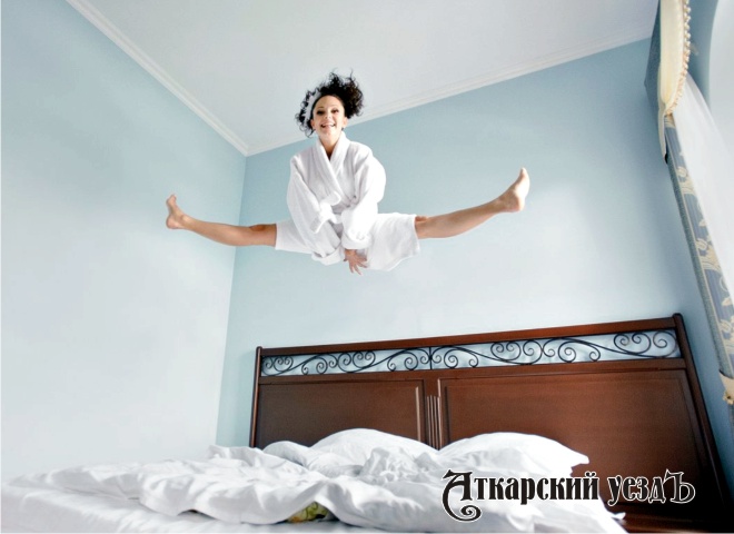 Девушка прыгает на кровати