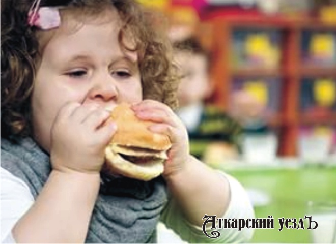 Девочка кушает гамбургер