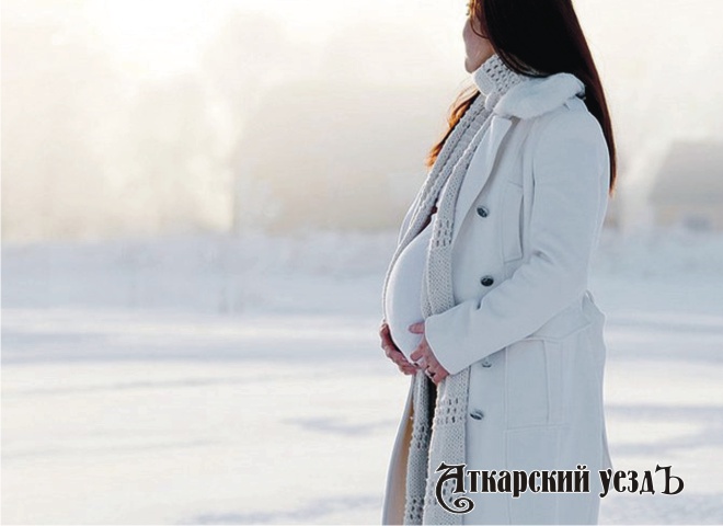Беременная женщина на фоне зимы