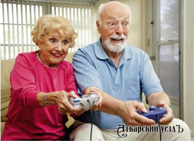 Дедушка и бабушка играют в компьютерную игру