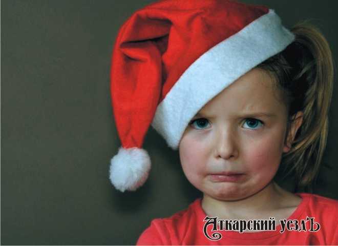 Девочка в шапке Санта Клауса плачет