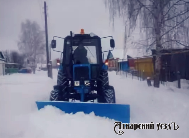 Расчистка дороги от снега трактором